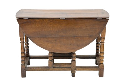 Lot 698 - An oak gateleg dining table.