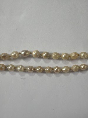 Lot 192 - A natural saltwater and cultured graduated pearl necklace, strung to a diamond clasp.