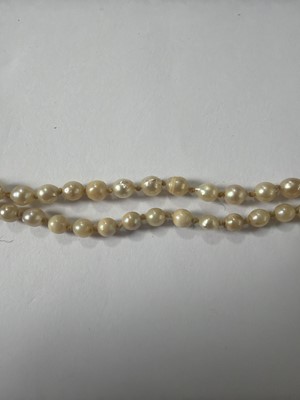 Lot 192 - A natural saltwater and cultured graduated pearl necklace, strung to a diamond clasp.