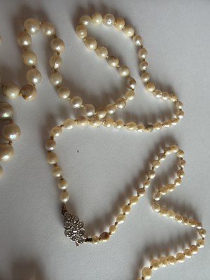 Lot 192 - A natural saltwater and cultured graduated pearl necklace, strung to a diamond clasp.