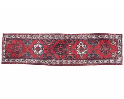 Lot 469 - A red ground carpet runner.
