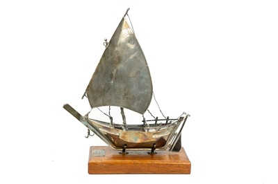 Lot 373 - A white metal model of a Middle Eastern sailing boat or dhow.