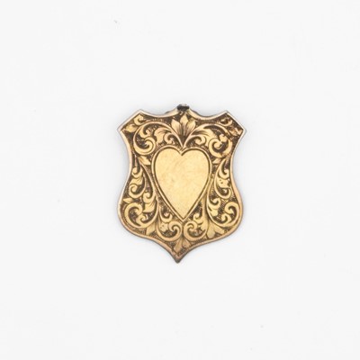 Lot 56 - An Edwardian 9k small shield-shaped brooch.