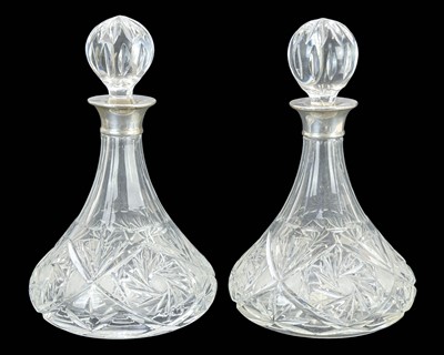 Lot 558 - A pair of cut glass sherry decanters with silver collars.