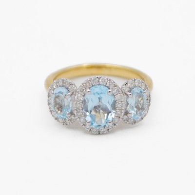Lot 92 - A 9k white and yellow gold blue topaz and diamond set triple cluster ring.