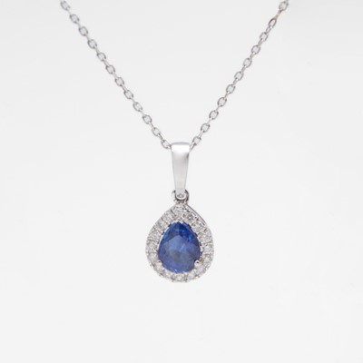 Lot 99 - An 18k white gold pear-cut sapphire and diamond cluster pendant on 18k chain.
