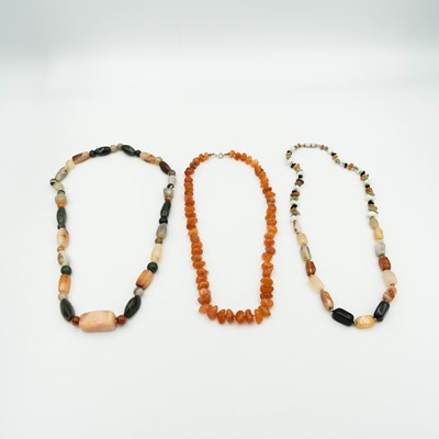Lot 95 - A Carnelian bead necklace and two hard-stone bead necklaces.