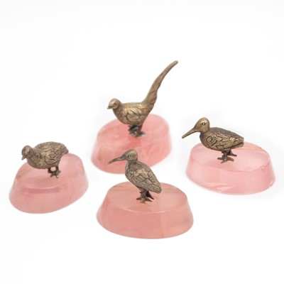Lot 120 - A cased set of four silver-gilt game bird markers on rose quartz stands by Edwards & Sons.