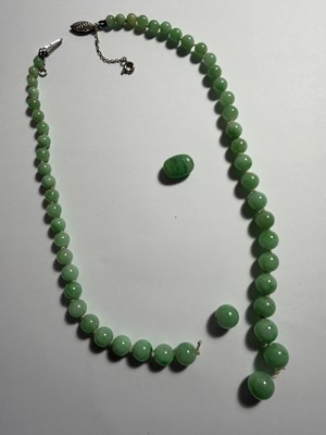 Lot 4 - A green jadeite graduated bead necklace with white gold clasp, in need of re-stringing.