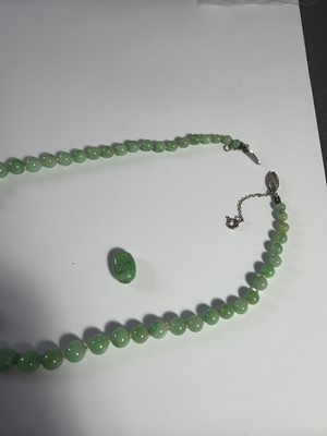Lot 4 - A green jadeite graduated bead necklace with white gold clasp, in need of re-stringing.