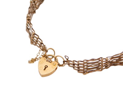 Lot 28 - A 9k five-bar gate bracelet with padlock clasp.