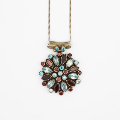 Lot 142 - A silver garnet and blue stone pendant, on a silver neck chain.