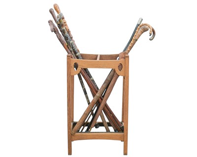 Lot 23 - A collection of walking sticks and canes in an Art Nouveau oak stand.