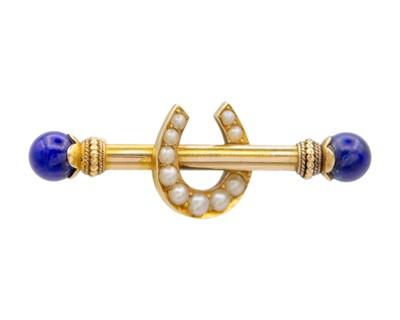 Lot 44 - A Victorian 15k gold horseshoe bar brooch set with lapis lazuli and seed pearls.