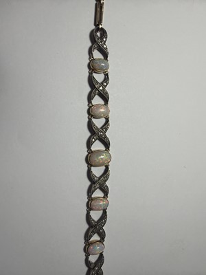 Lot 77 - An early 20th century white precious opal and diamond set gold bracelet, within J.W. Benson Ltd box.