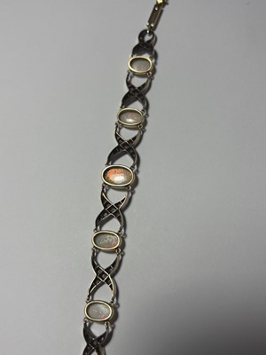 Lot 77 - An early 20th century white precious opal and diamond set gold bracelet, within J.W. Benson Ltd box.