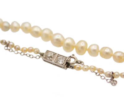 Lot 115 - A graduated pearl necklace strung to a white gold clasp set with two old mine-cut diamonds.