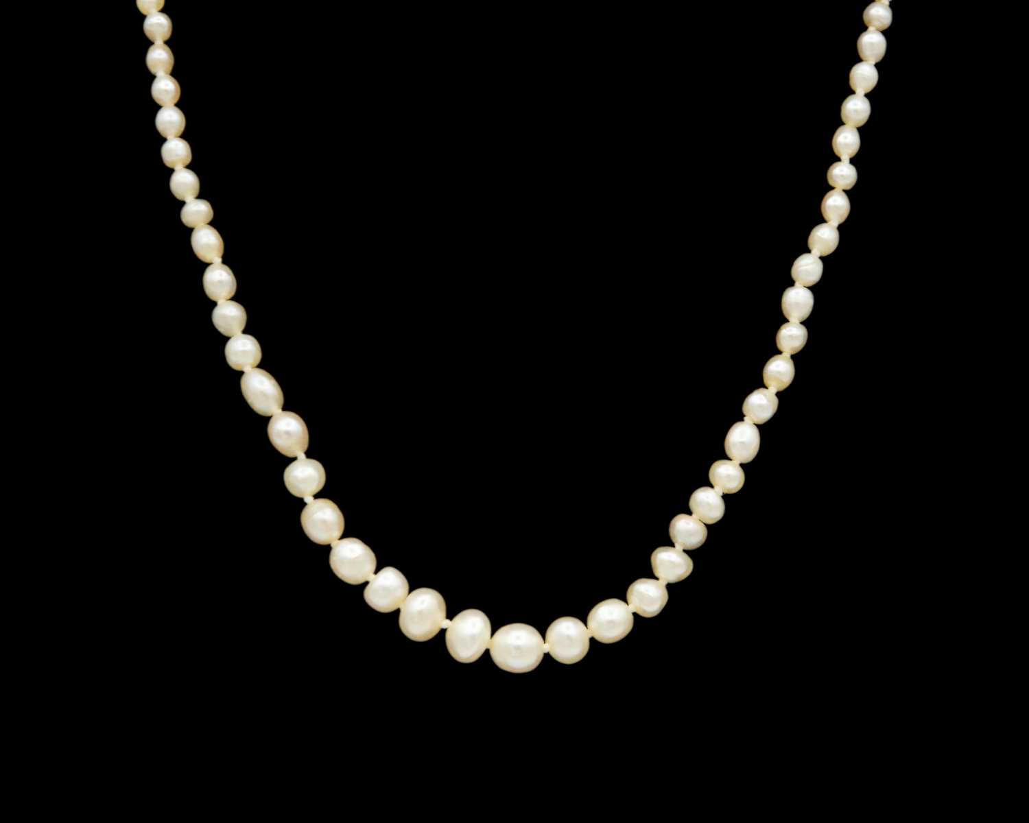 Lot 115 - A graduated pearl necklace strung to a white gold clasp set with two old mine-cut diamonds.