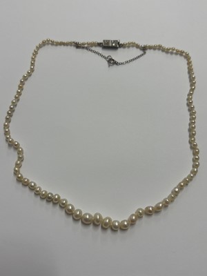 Lot 115 - A graduated pearl necklace strung to a white gold clasp set with two old mine-cut diamonds.