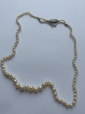 Lot 115 - A graduated pearl necklace strung to a white gold clasp set with two old mine-cut diamonds.