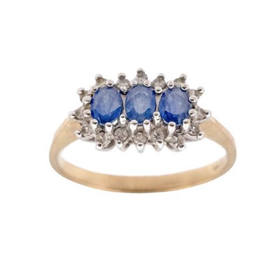 Lot 135 - A 9k hallmarked gold three-stone sapphire ring with accent melee diamonds.
