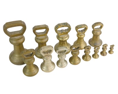 Lot 3 - A pair of teak and brass candlesticks.