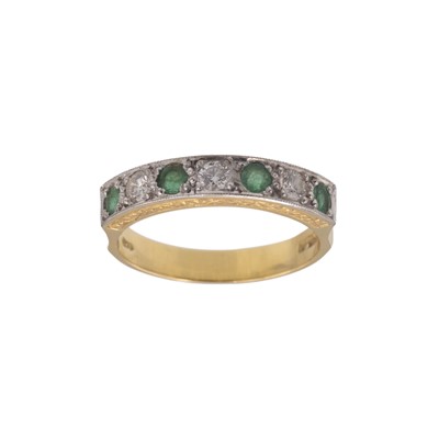 Lot 197 - An 18k emerald and diamond set seven stone half hoop ring.
