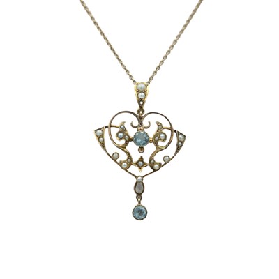 Lot 119 - An Edwardian Art Nouveau 9k aquamarine, paste and seed pearl set pendant, on a 9k chain.