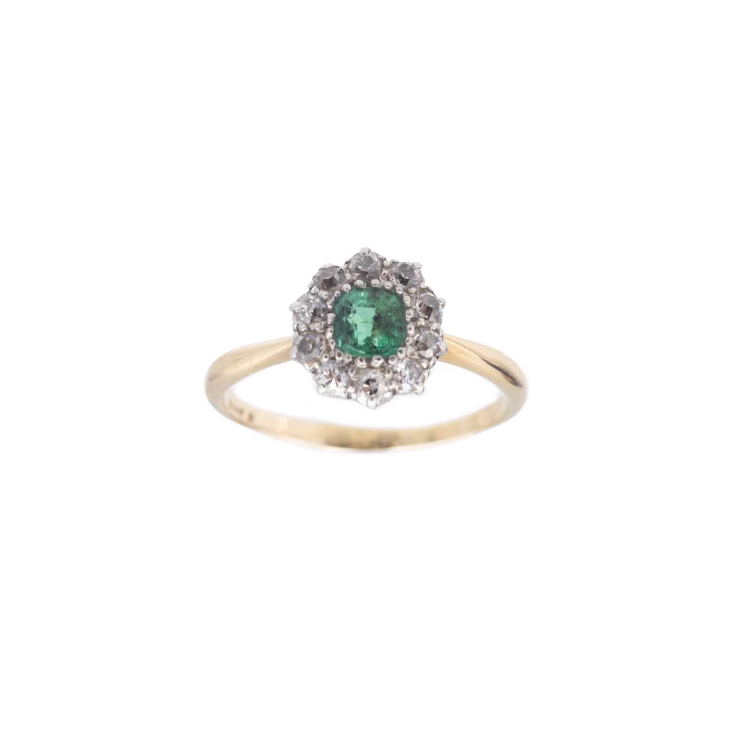 Lot 128 - An attractive early 20th-century emerald and diamond cluster ring, set in 18k gold.
