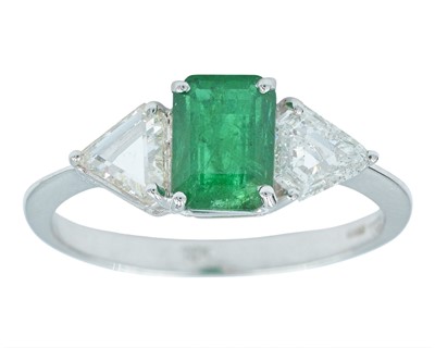 Lot 137 - An attractive 18k white gold emerald and diamond three-stone ring.