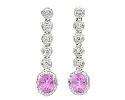 Lot 170 - A pair of 18k white gold drop earrings set with oval pink sapphires and diamonds.