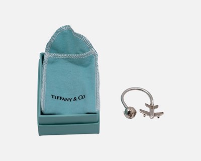 Lot 151 - TIFFANY & CO - A 925 silver keyring, in the form of a globe and aeroplane, with box and pouch.