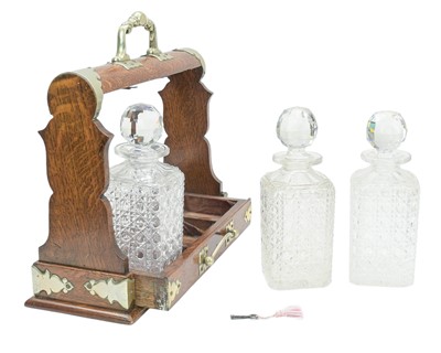 Lot 76 - An Edwardian oak three bottle tantalus.