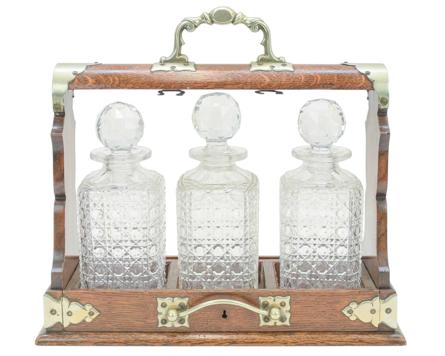 Lot 76 - An Edwardian oak three bottle tantalus.