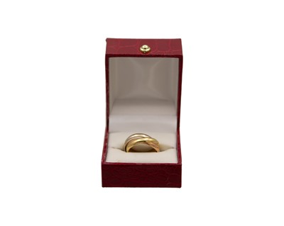 Lot 271 - MUST DE CARTIER - An 18k tr-colour gold 'Trinity' ring, with box and certificate.