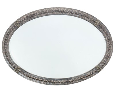 Lot 819 - An Arts and Crafts silvered copper oval wall mirror.