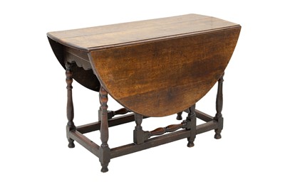 Lot 684 - A George III oak oval oak gate leg dining table.