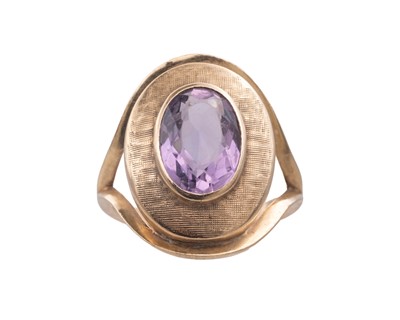 Lot 48 - A Modernist 9k oval cut amethyst set dress ring.