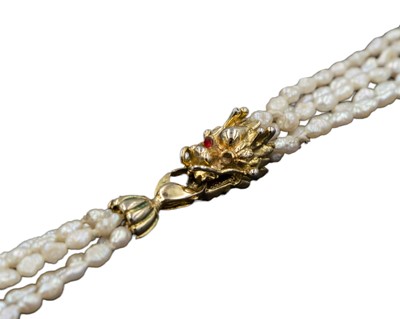 Lot 475 - A five strand cultured baroque pearl necklace, strung to a silver gilt Chinese dragon head clasp.