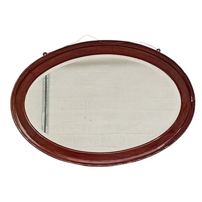Lot 110 - An oval mahogany bevelled edge wall mirrow. 55...