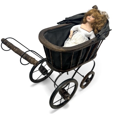 Lot 180 - A vintage bisque head doll and pram.