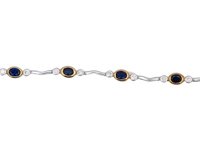 Lot 45 - A modern 18k yellow and white gold oval blue sapphire and diamond set bracelet.