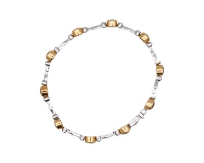 Lot 45 - A modern 18k yellow and white gold oval blue sapphire and diamond set bracelet.