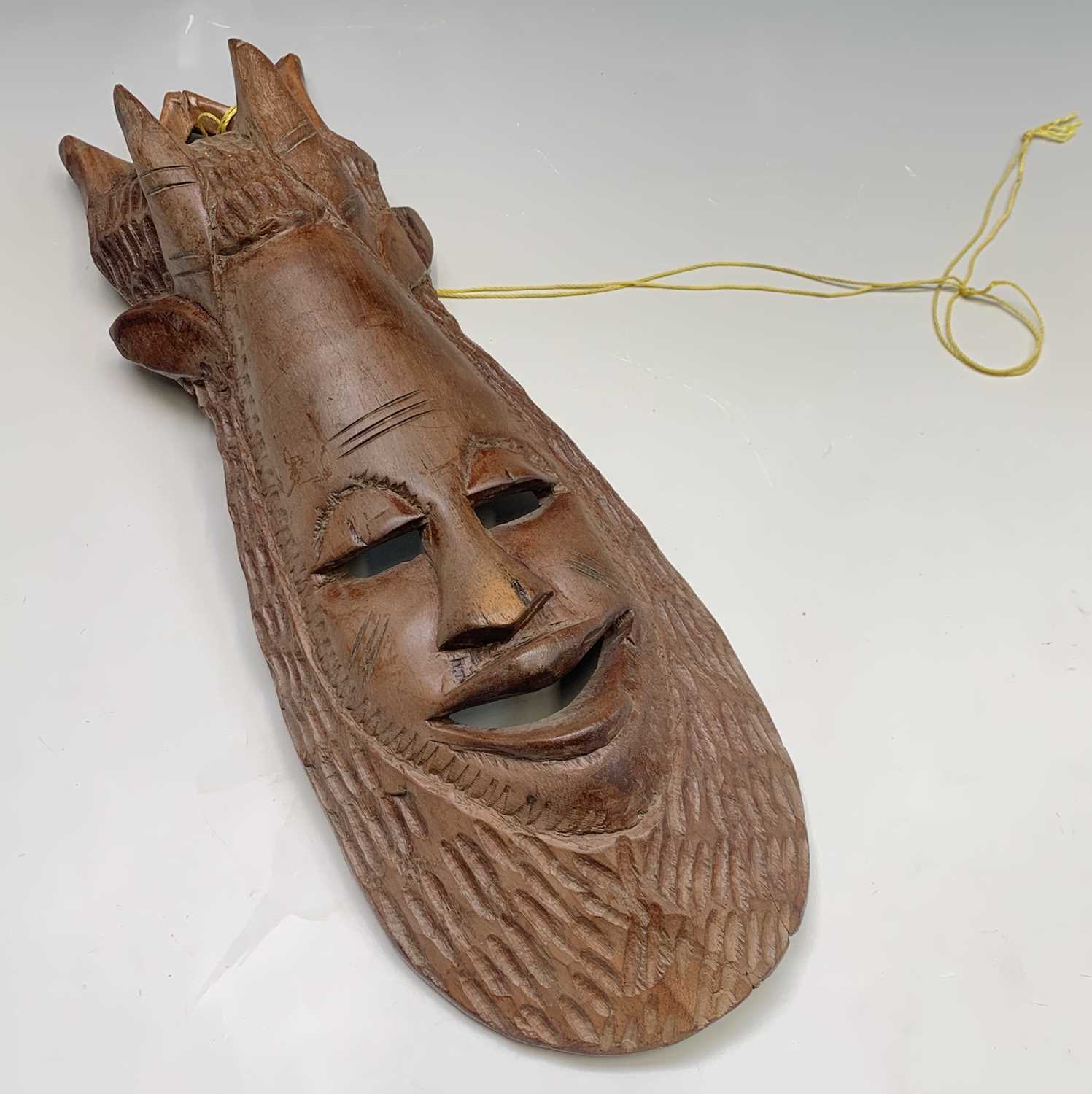 Lot 117 - An African carved wood mask. Height 54cm.
