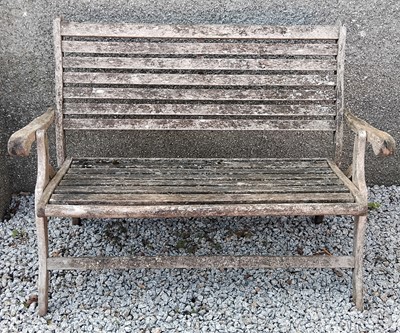 Lot 440 - A weathered teak folding garden bench.