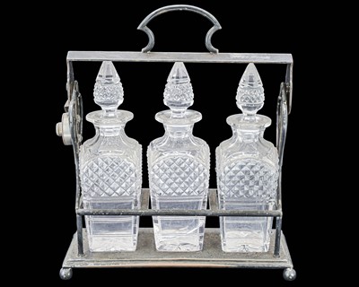 Lot 82 - A silver plated three bottle tantalus.