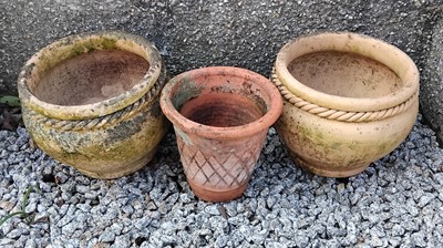 Lot 425 - A pair of terracotta planters with rope twist decoration.