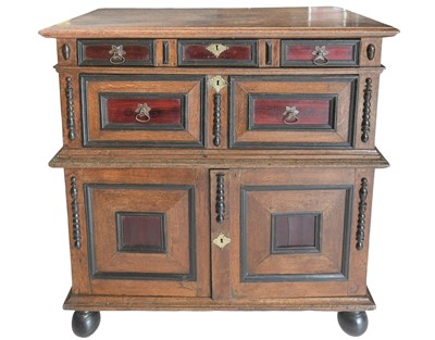 Lot 696 - A 17th century oak and snakewood cabinet on chest.