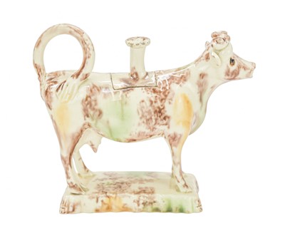 Lot 629 - A creamware Whieldon type cow creamer and cover.
