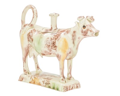 Lot 629 - A creamware Whieldon type cow creamer and cover.
